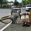 A cop car parked next to a fire hydrant with a hose sticking out of it..jpg